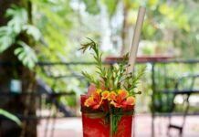 여름철 운동 후 탈수 예방을 위한 음료 a tall red drink sitting on top of a wooden table
