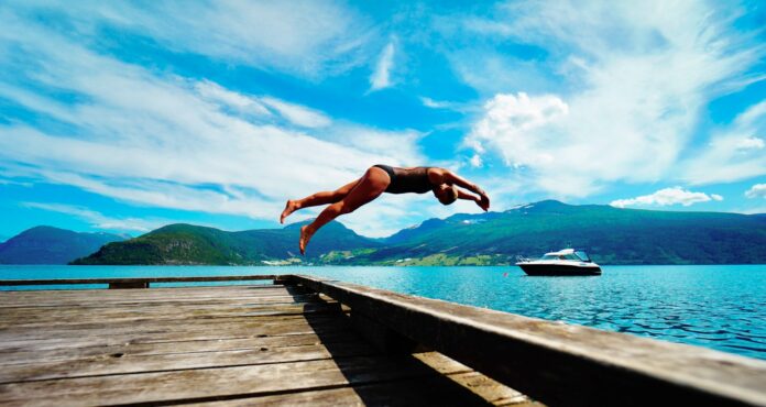 Photo by Charlotte Karlsen person jumping on body of water at daytime