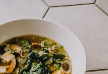 건강한 겨울을 위한 식습관 개선 아이디어 a white bowl filled with soup on top of a tiled floor