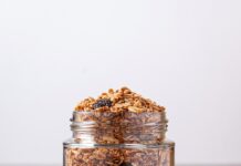 홈메이드 건강간식 A jar filled with granola next to a wooden spoon