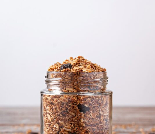 홈메이드 건강간식 A jar filled with granola next to a wooden spoon