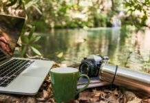 디지털 디톡스, 스트레스를 줄이고 삶의 질을 높이는 첫걸음 Laptop, camera, and mug by a forest stream