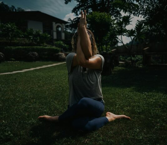 디톡스 요가: 비틀기 동작으로 체내 독소를 제거하는 ‘장 청소’ 가이드 a woman sitting on the ground with her hands in the air